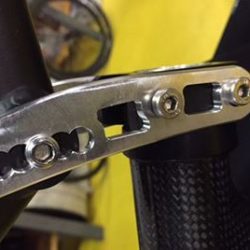 A close up of a bike with a metal handlebar clamp.