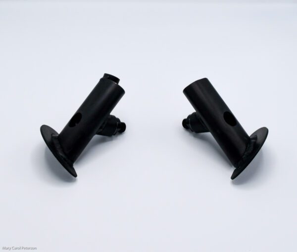 Two black plastic pipe fittings on a white surface.