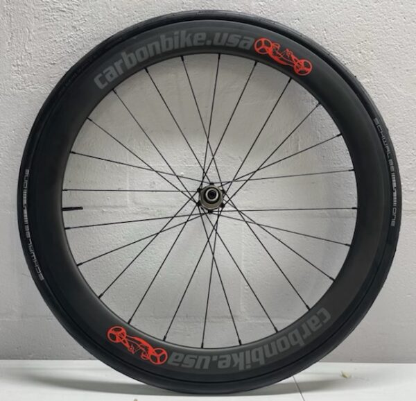 A HW-Carbonbike 650c carbon fiber drive wheel with orange lettering on it.