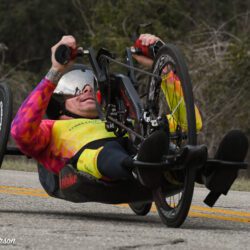 A person in a wheelchair riding down a road.