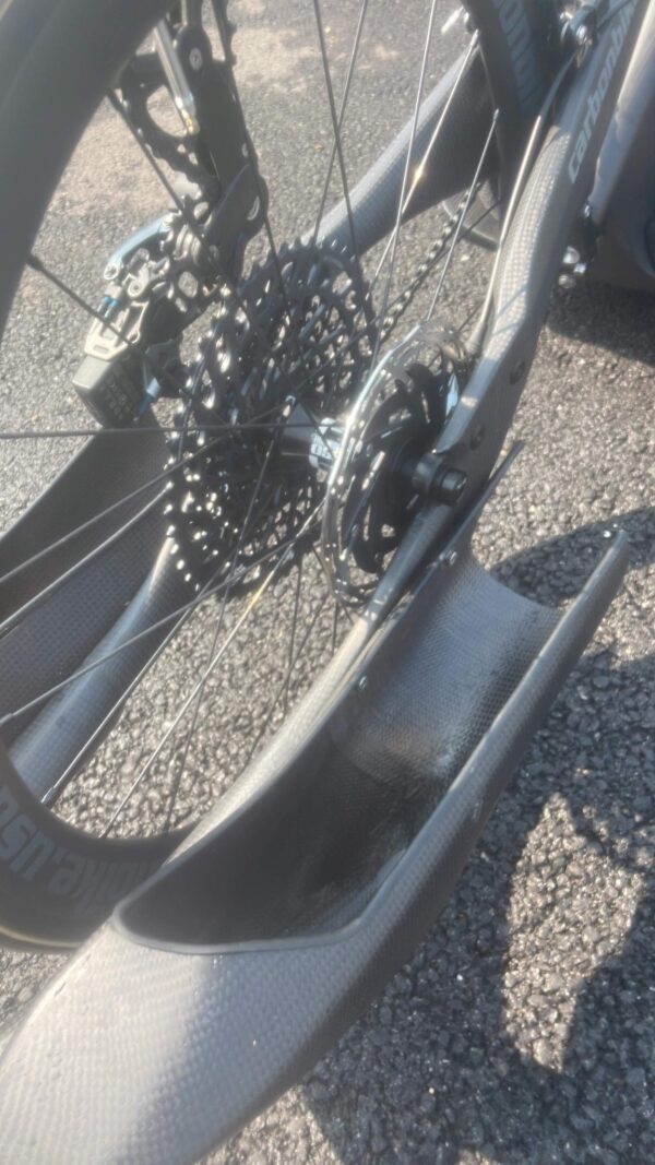 A close up of a bike with H Carbon fiber foot rests attached to it.