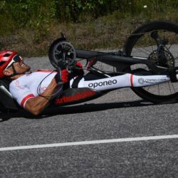 A man laying on his bike on the side of the road.