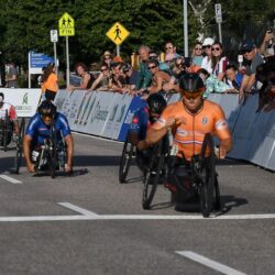 Some people riding hand cycles in race