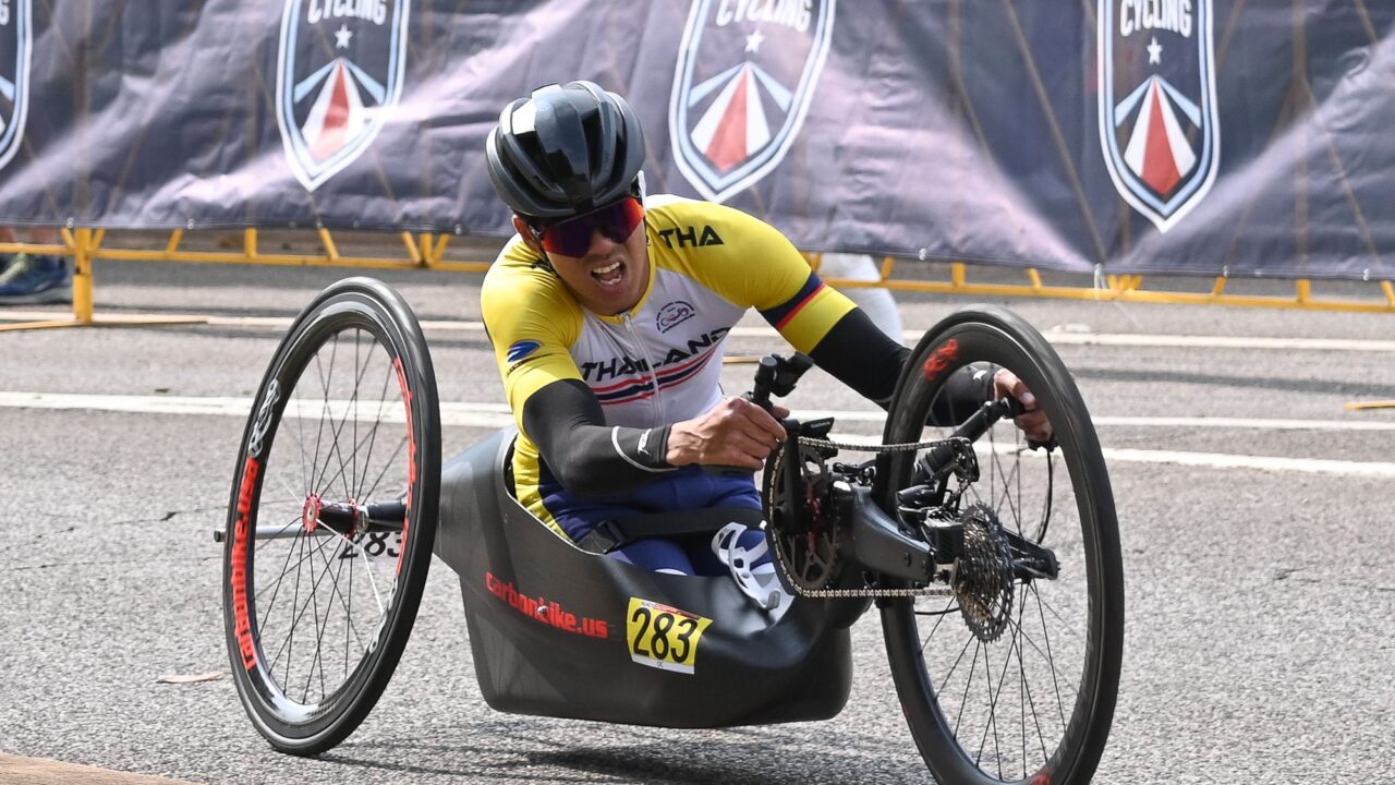 A man wearing a yellow jersey, riding a cycle