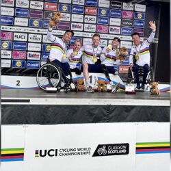 A group of people standing on a podium with their trophies.