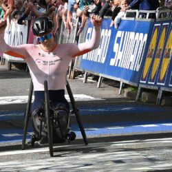 A man in a wheelchair with his arms raised in the air.