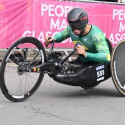 A man in a wheelchair is riding a bike in a race.
