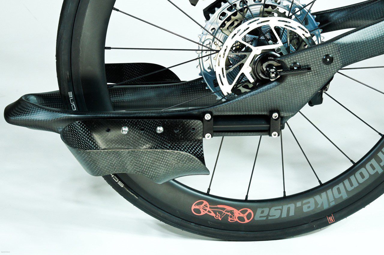 A close up of a bicycle wheel with H-Open Carbon Fiber Footrests.